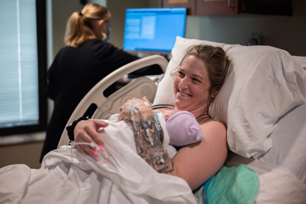A new mothers big smile after delivering her baby at Crestwood Memorial Hospital in Huntsville Alabama