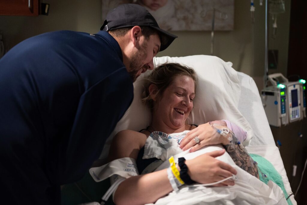 A mother holding her new baby for the first time as the father looks over them at Crestwood Memorial Hospital