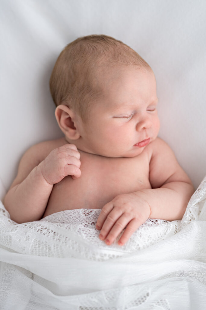 Newborn girl peacefully sleeps during her newborn photo session