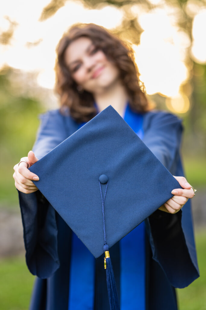 Close up of Senior girl/s cap while she smiles for the camera dressed in her cap and gown at Hayes Nature Preserve in Huntsville, Alabama