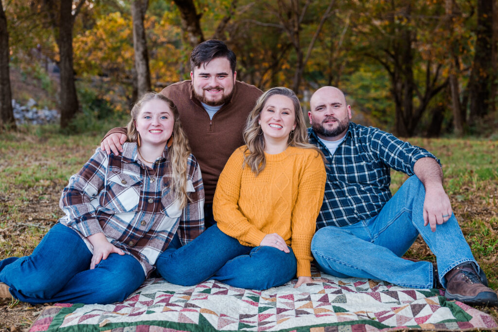 Family of four sitting on the ground at Hayes Nature Preserve in Huntsville Alabama