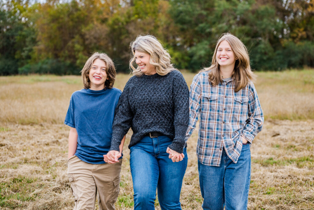 A family walking in a field together at Hayes Nature Preserve in Huntsville Alabama