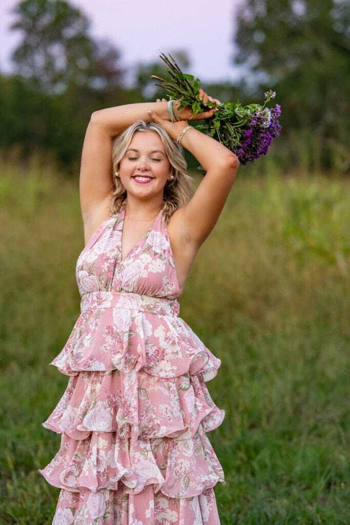 Senior girl in ruffled dress holding purple flowers for pictures at Hayes Nature Preserve in Huntsville AL