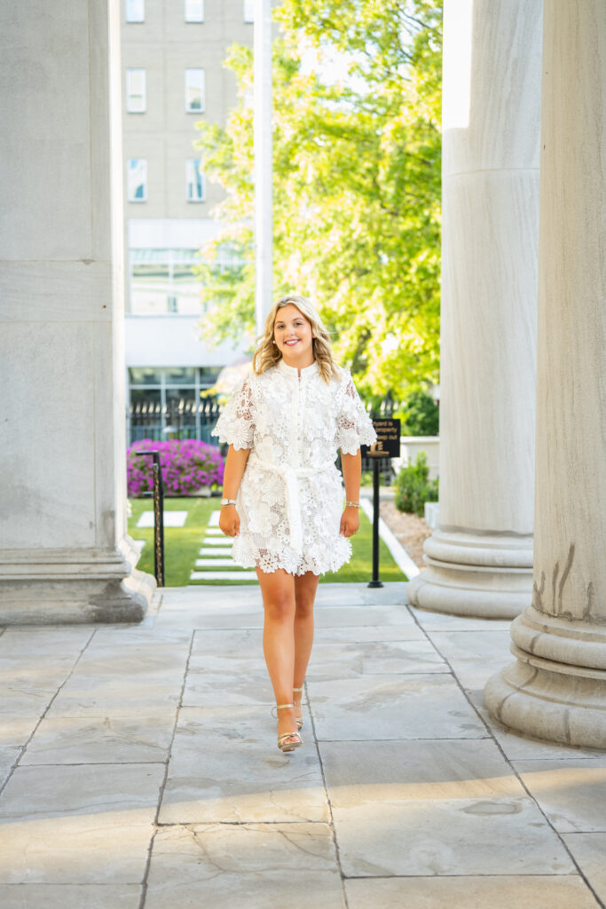 A senior girl walking by the columns at the Historic First National Bank in downtown Huntsville